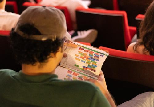 Persona revisando la programación del FICCI 64